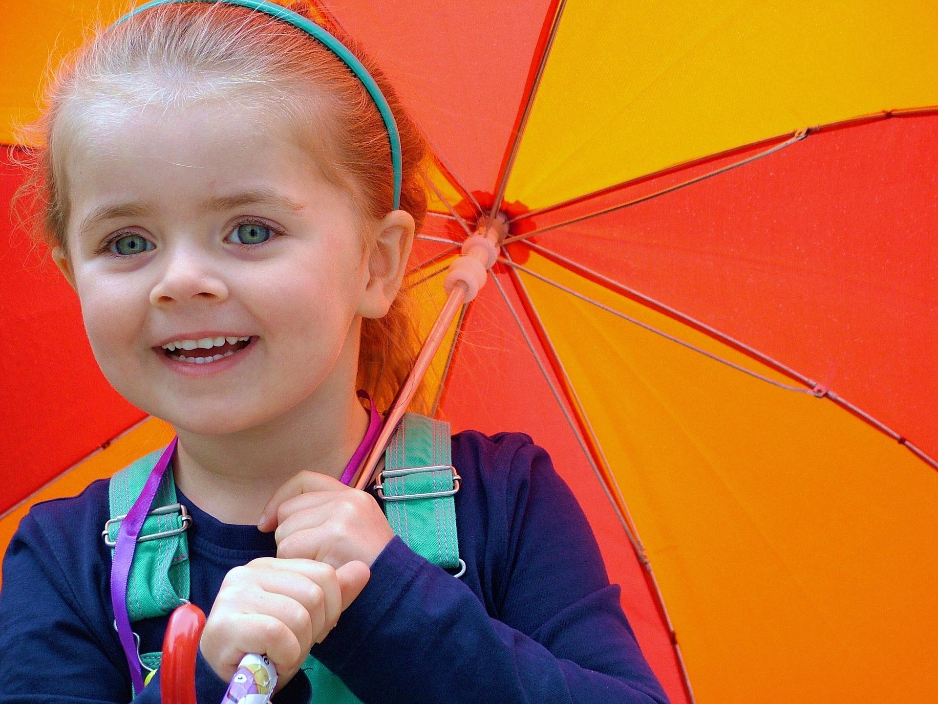 imagen niña con paraguas amarillo y rojo 